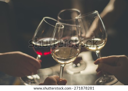 Wining with friends\
Four friends cheering\
Drinking wine in a restaurant