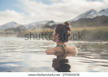 Girl in a hot spring in Iceland Landmannalaugar. Relaxing in a natural hot bath.