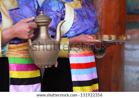 Tibetan women serving traditional style milk tea, Shangri-La, China