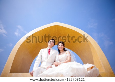 In love bride and groom are posing in romantic emotion on top of a tower