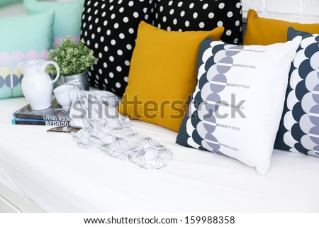 Colorful pillows on a sofa with white brick wall in background