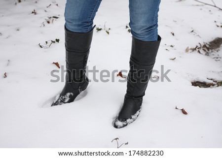 Young woman wears Jeans with black walking boots in the snow