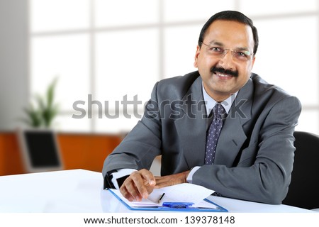Young Indian business man sitting at his desk
