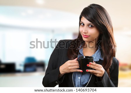 Beautiful asian businesswoman holding coffee cup in her office time.