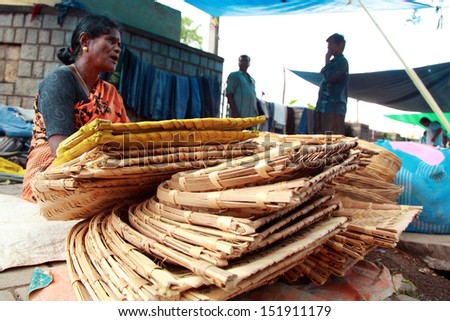 BANGALORE, INDIA - AUGUST 25: Unidentified lady sells bamboo products  on August 25, 2013 in Madiwala market in Bangalore, India. Bamboo is one of the fastest-growing plants on Earth.