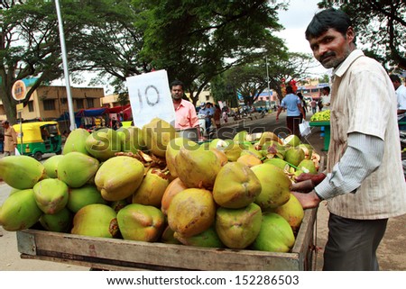 BANGALORE - AUGUST 25 .Coconut  seller in crowded market  on August 25, 2013 at Madiwala market ,Bangalore ,India. The coconut palm thrives on sandy soils and is highly tolerant of salinity
