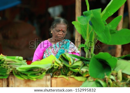 BANGALORE, INDIA - AUGUST 25: Unidentified lady selling plantain leaf on a city street on August 25, 2013 in Madiwala market, Bangalore, Karnataka, India.
