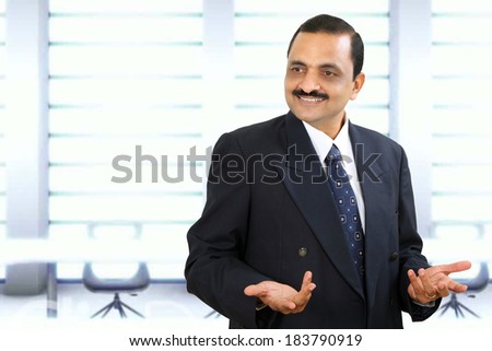 Happy Indian business man showing some action with his hands.