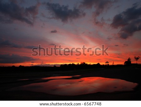 reflection of colorful sky on ground water pool