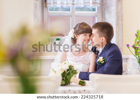Bride and groom at table in cafe