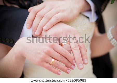 Wedding  gold rings on the hands of the bride and groom