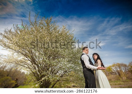 Bride and groom on the blue sky spring tree flover