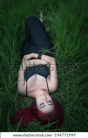 asian young red hair woman lay down on green grass