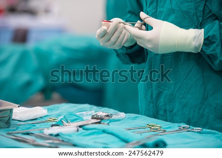 scrub nurse preparing medical instruments for operation