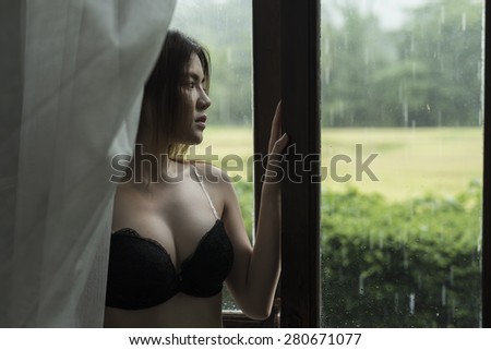 asian woman sitting beside window