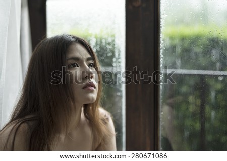 asian woman sitting beside window