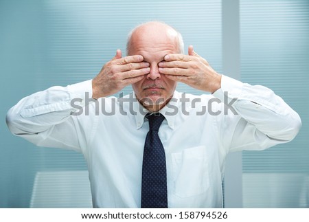businessman covering his eyes with his hands