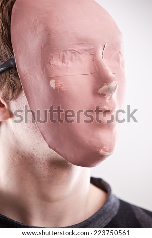a young man disguised behind a pink mask