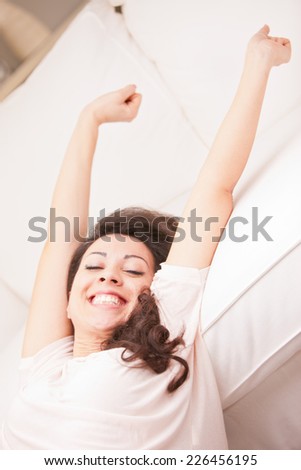 this girl is girl stretching and yawning in the morning in her living room