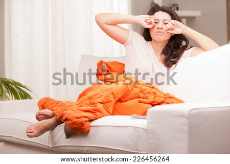 this girl is girl stretching and yawning in the morning in her living room