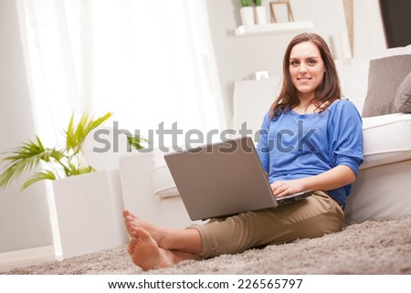this beautiful self confident girl uses her notebook in relax in her living room