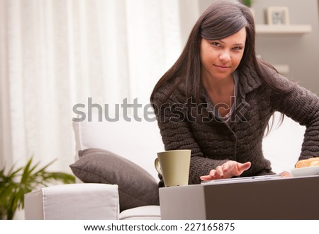 she works and has breakfast on the couch of her living room because she can work at home