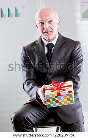 an elegant business man has a gift in his hands