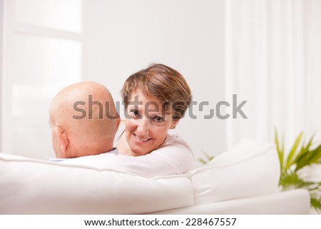 old woman and old men happy together because they love each other in a living room on a sofa