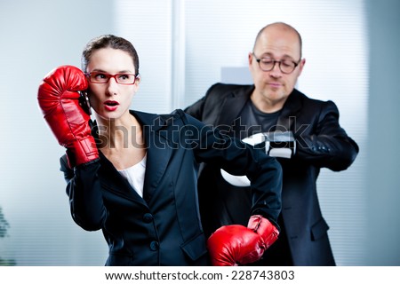 business woman answers the phone during a boxe match with a business man watching his watch impatiently