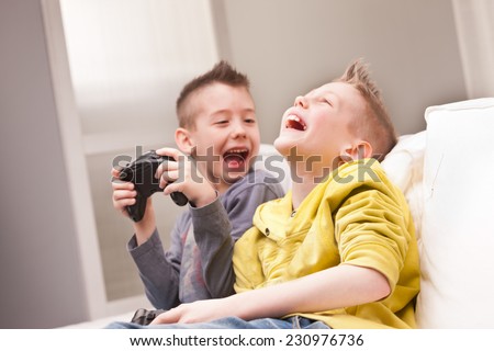 two little boys having lots of fun with video games