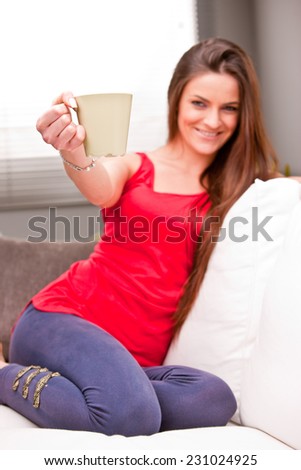 woman offering a hot drink in a mug of some hot drink