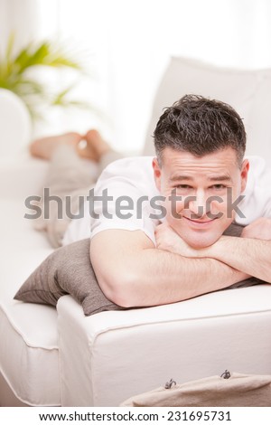 relaxed man having finally his time off in his living room and his beloved  couch