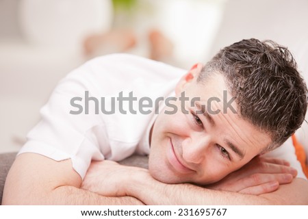 relaxed man having finally his time off in his living room and his beloved  couch