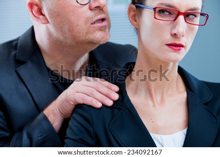 violent man menacing an office worker woman maybe his colleague or subordinate