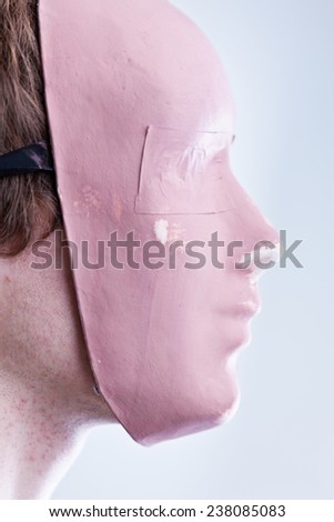 man with mask in a foreground portrait brightly lit