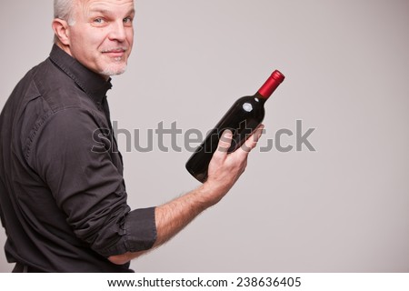 proud wine maker man with a bottle of excellent red wine