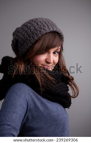 winter dressed pretty woman smiling on a neutral background
