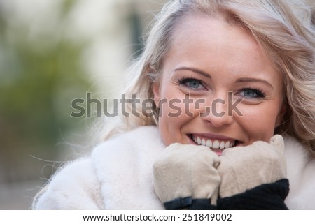 intense look of a SMILING woman in winter walking across the streets of an european city