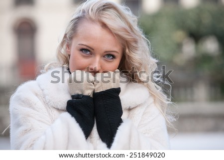 intense look of a woman in winter walking across the streets of an european city