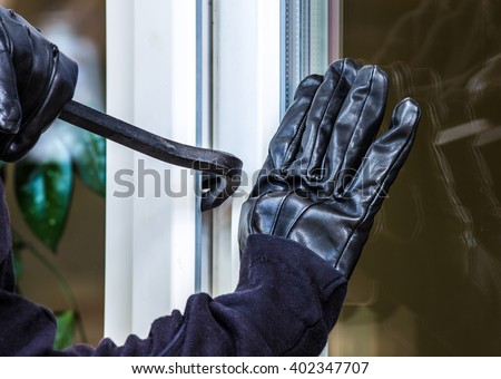 a burglar levers on a window