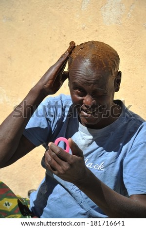 BORAMA, SOMALIA - JANUARY 13, 2010:  Old Somali dye his hair with henna in the street of the city of Borama. Located near the border with Ethiopia. Much of the population lives in poverty.