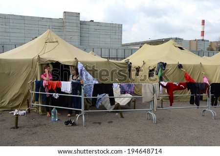 MOSCOW, RUSSIA - AUGUST 5, 2013:  Temporary camp for displaced persons contains illegal migrants from Asian countries, discovered during police raids, pending deportation to their homeland.