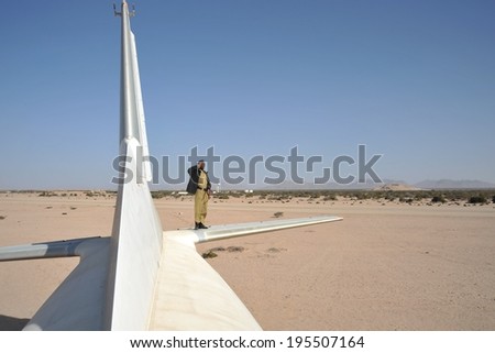 BERBERA, SOMALIA - JANUARY 10, 2010: The police officer by crashed plane at the airport of Berbera. Berbera is a city on the North-West of the state of Somalia, with  sheltered Harbor in  Gulf of Aden