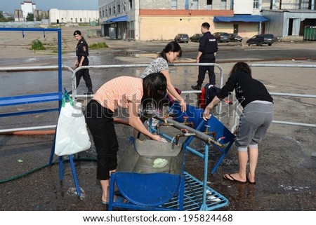 MOSCOW, RUSSIA - AUGUST 5, 2013:  Temporary camp for displaced persons contains illegal migrants from Asian countries, discovered during police raids, pending deportation to their homeland.