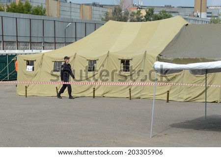 MOSCOW, RUSSIA - AUGUST 1, 2013:  Temporary camp for displaced persons contains illegal migrants from Asian countries, discovered during police raids, pending deportation to their homeland.