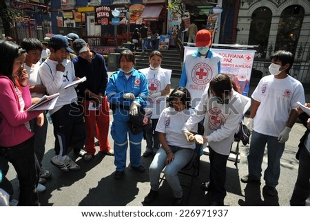 LA PAZ, BOLIVIA - SEPTEMBER 12, 2010: The actual capital of Bolivia, where most of the state institutions. Activists of the red cross teach people first aid on a city street.