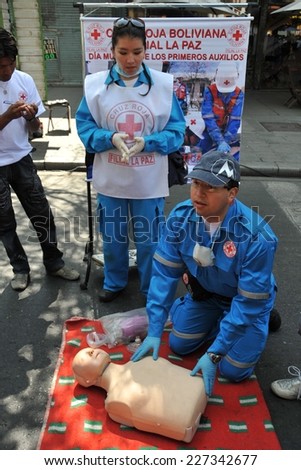 LA PAZ, BOLIVIA - SEPTEMBER 12, 2010: The actual capital of Bolivia, where most of the state institutions. Activists of the red cross teach people first aid on a city street.