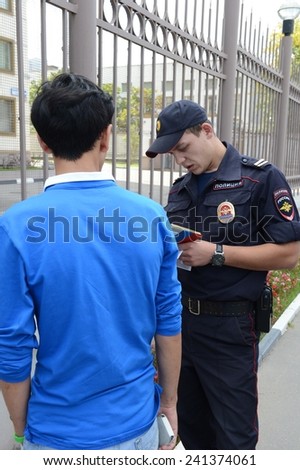 MOSCOW, RUSSIA - AUGUST 8, 2013: Police officers inspect the documents on the streets of Moscow. Patrol and inspection service of the police provides public safety in the capital.