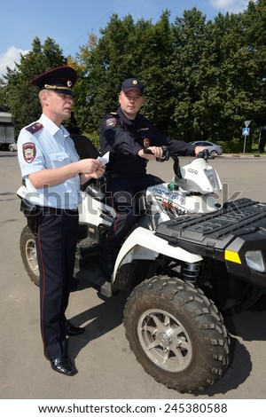 KHIMKI, RUSSIA - AUGUST 9, 2013: Police patrol the streets  in the suburban town of Khimki on the quadrocycle. Patrol and inspection service of the police provides public safety in the city.