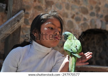 POTOSI, BOLIVIA - SEPTEMBER 7,2010: The unknown girl with the parrot on the streets of Potosi. Potosi is one of highest cities in world.